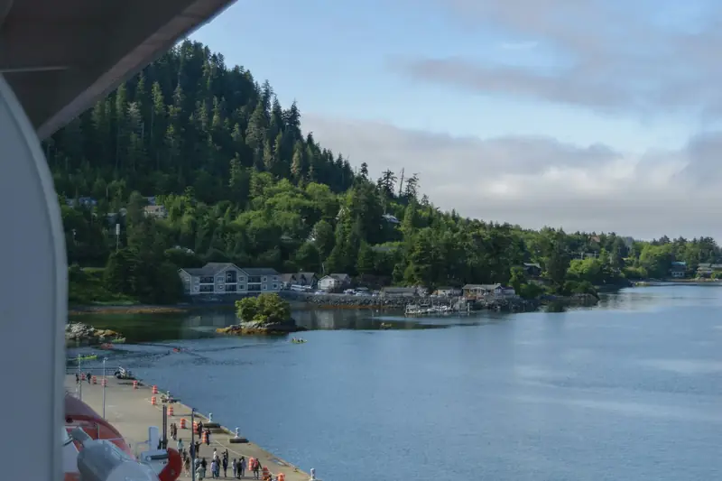 Forested Alaskan coastline seen from the side of a cruise ship near Sitka